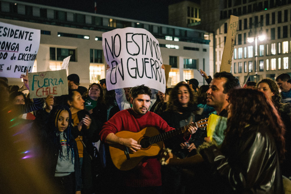 No estamos en guerra reza la pancarta de uno de los manifestantes a raíz de los dichos del presidente Piñera quien calificó la situación actual como un estado bélico - oto: Ramón Vásquez Lemus - Lado|B|erlin